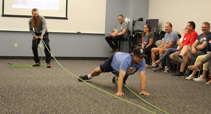 Adults participate in an exercise using ropes during a family seminar with outward bound.